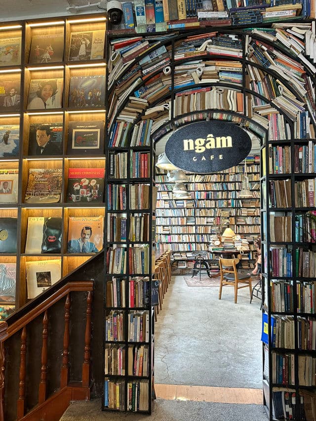 Vòm sách đen với biển hiệu oval ngâm CAFE treo giữa