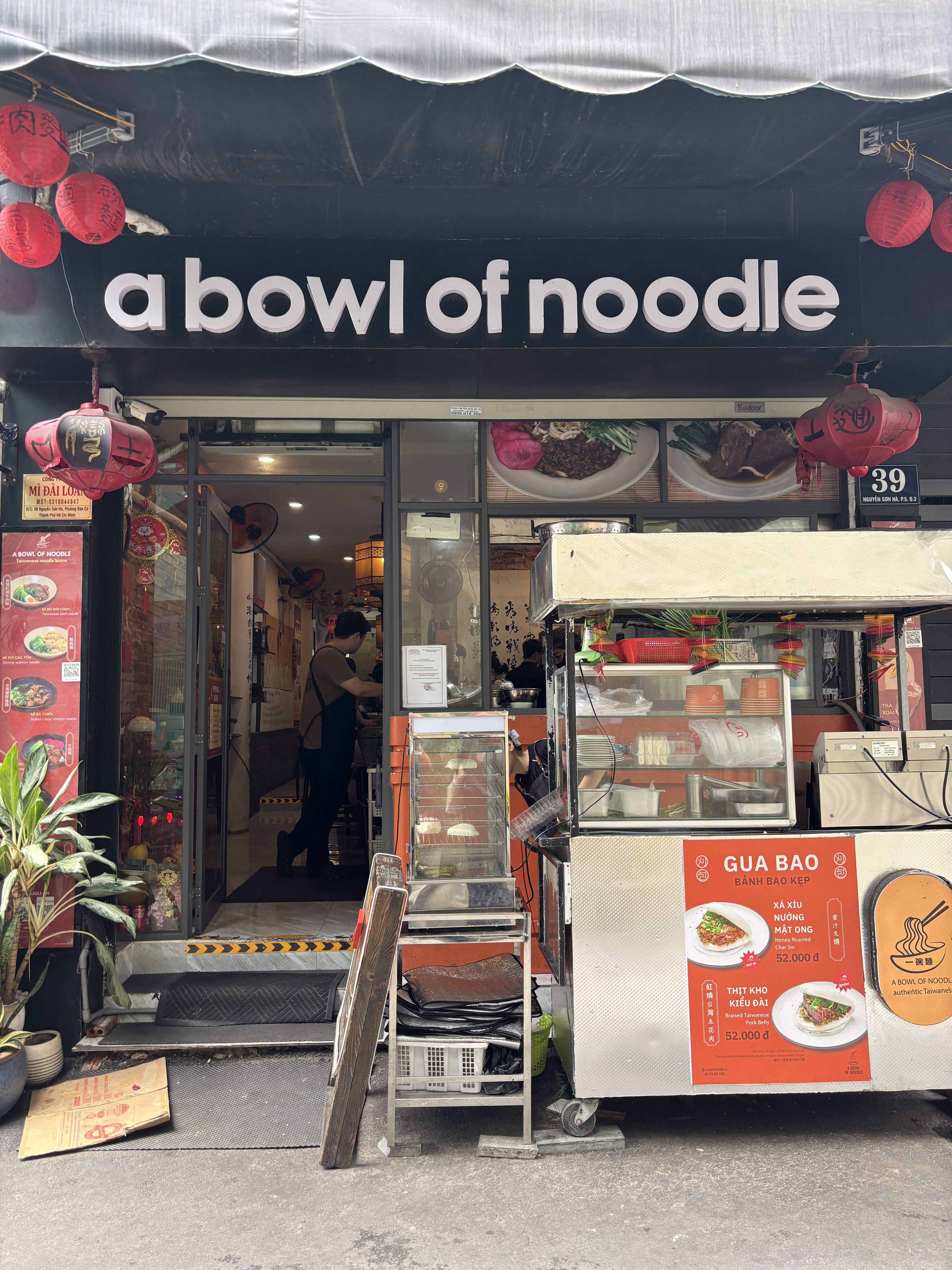 The black storefront with white lettering and red lanterns