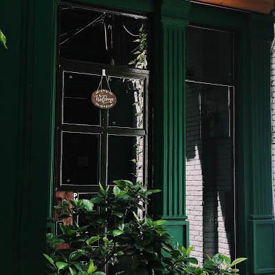 AKOMA Café & Fusion — cửa sổ xanh và bảng gỗ Welcome treo