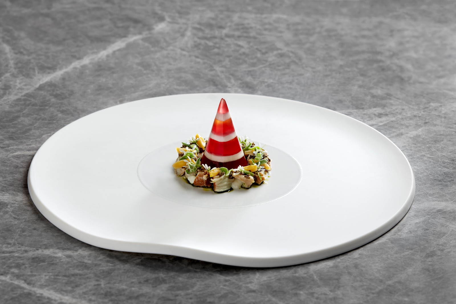 Red-and-white striped blood plum jelly cone on a tartare ring