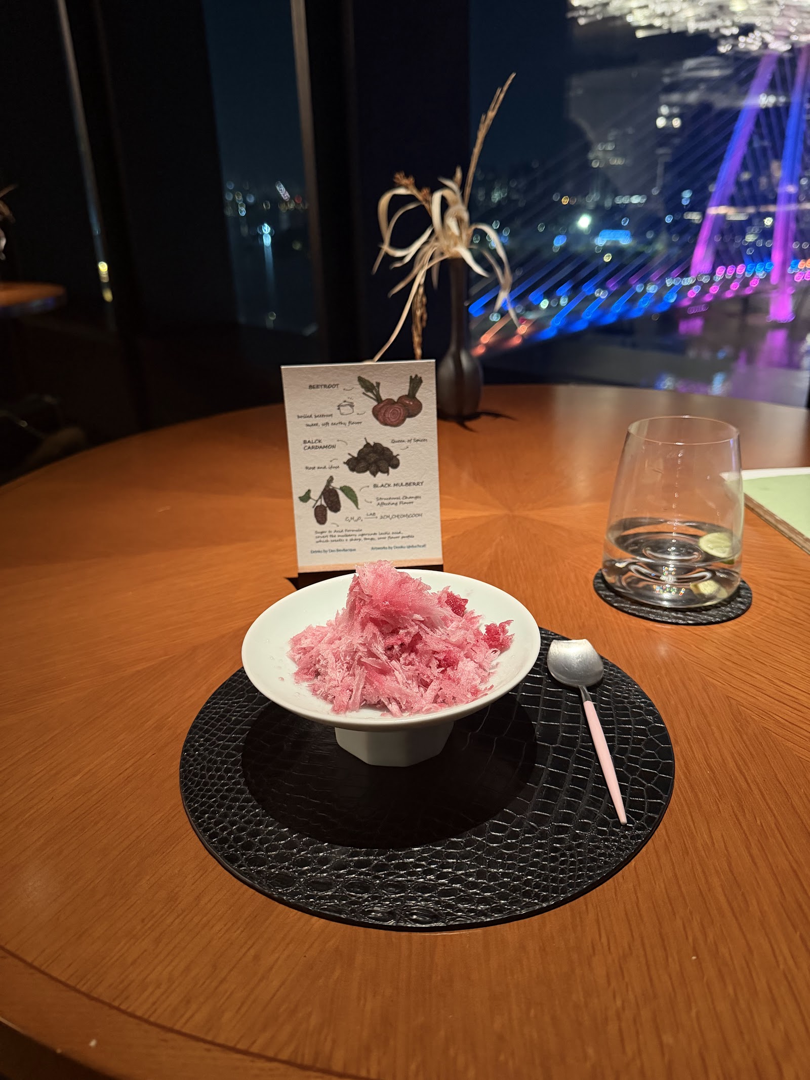 Pink shaved-ice dessert, the Ba Son Bridge glowing through the window