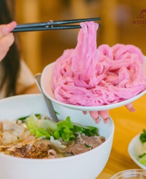 Sợi phở atiso hồng được gắp lên — màu hồng từ atiso Đà Lạt