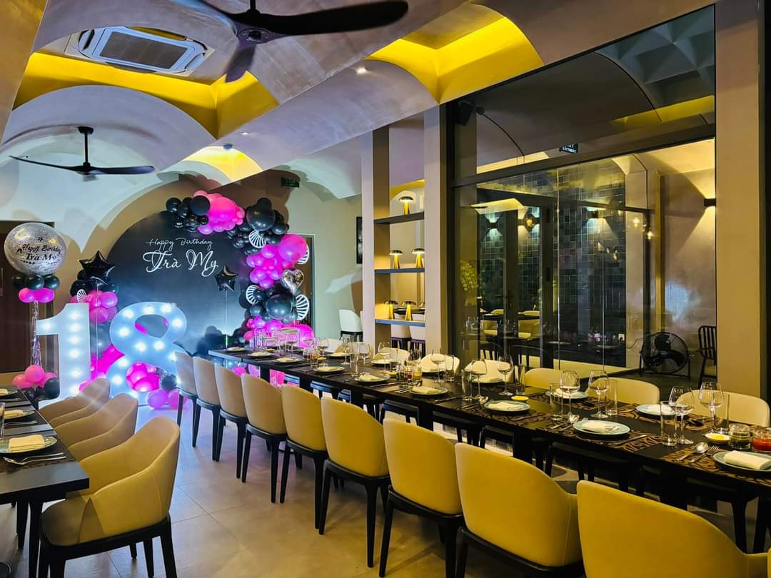 Phòng ăn 48 Bistro trong buổi tiệc sinh nhật — bàn dài phủ khăn, bóng bay và hoa (ảnh của quán, 11/2024)
