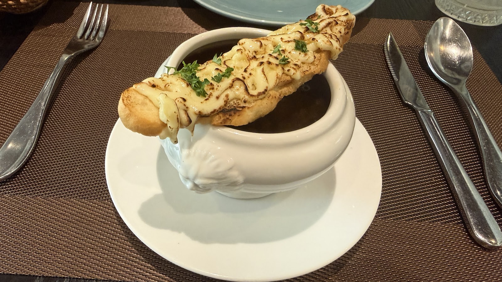French onion soup with a golden cheese crouton, served in the lion-head-handled tureen (diner photo by Thanh Hai Ng, Oct 2026)