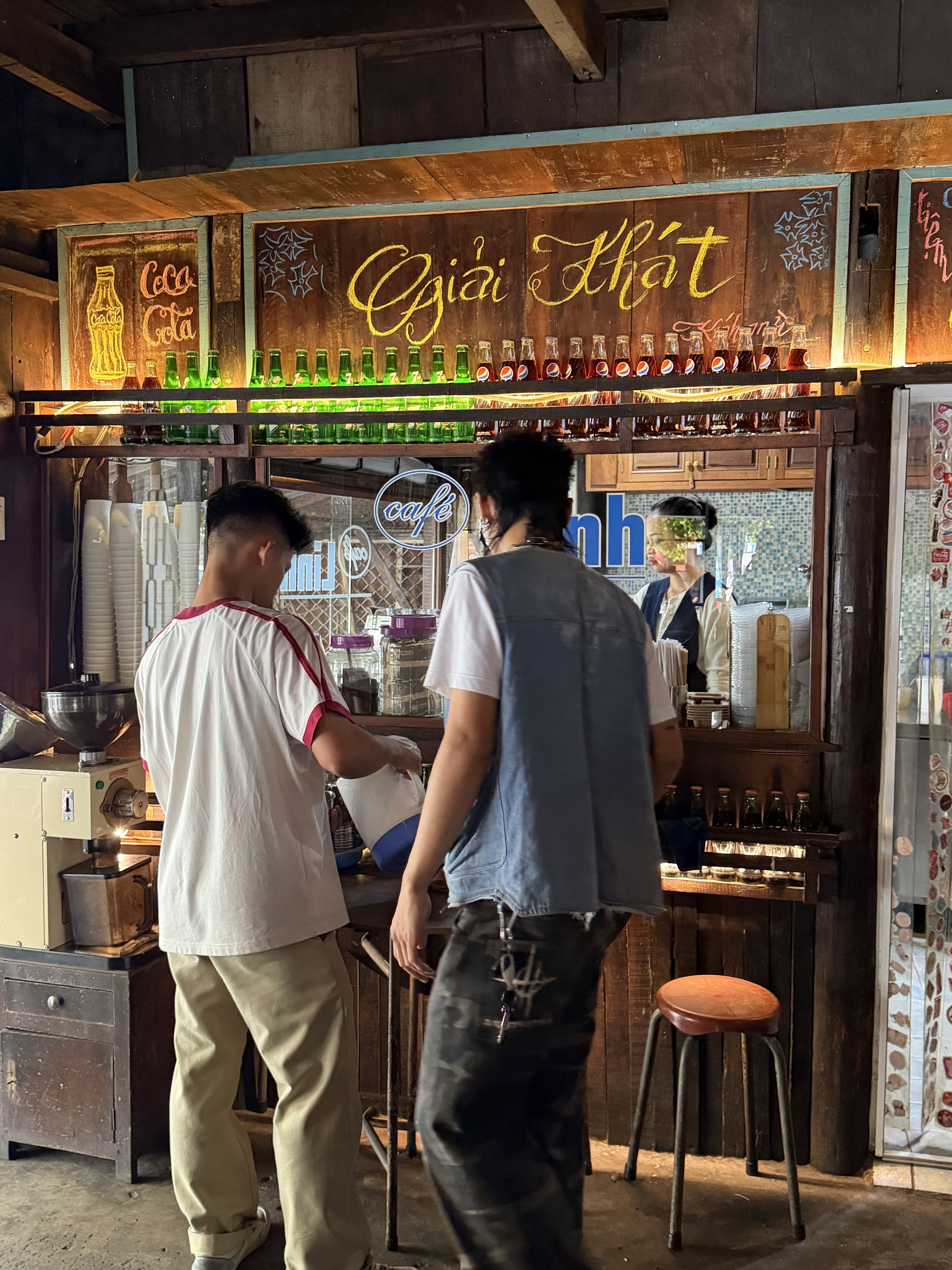 The brew counter with the Giải Khát sign and bottle shelves