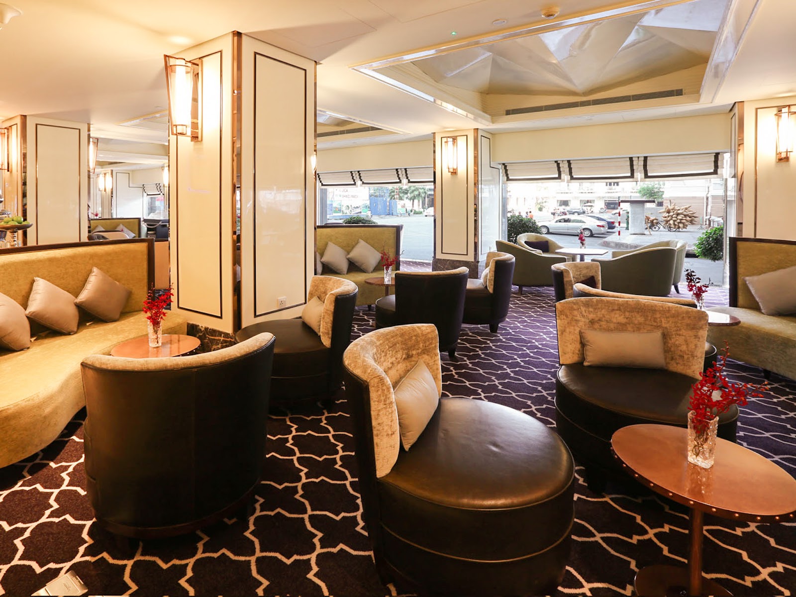 Phòng trà Café de l'Opéra: hàng cột ốp kem-vàng, ghế bành gỗ sẫm và ghế sofa, cửa sổ nhìn ra Công trường Lam Sơn