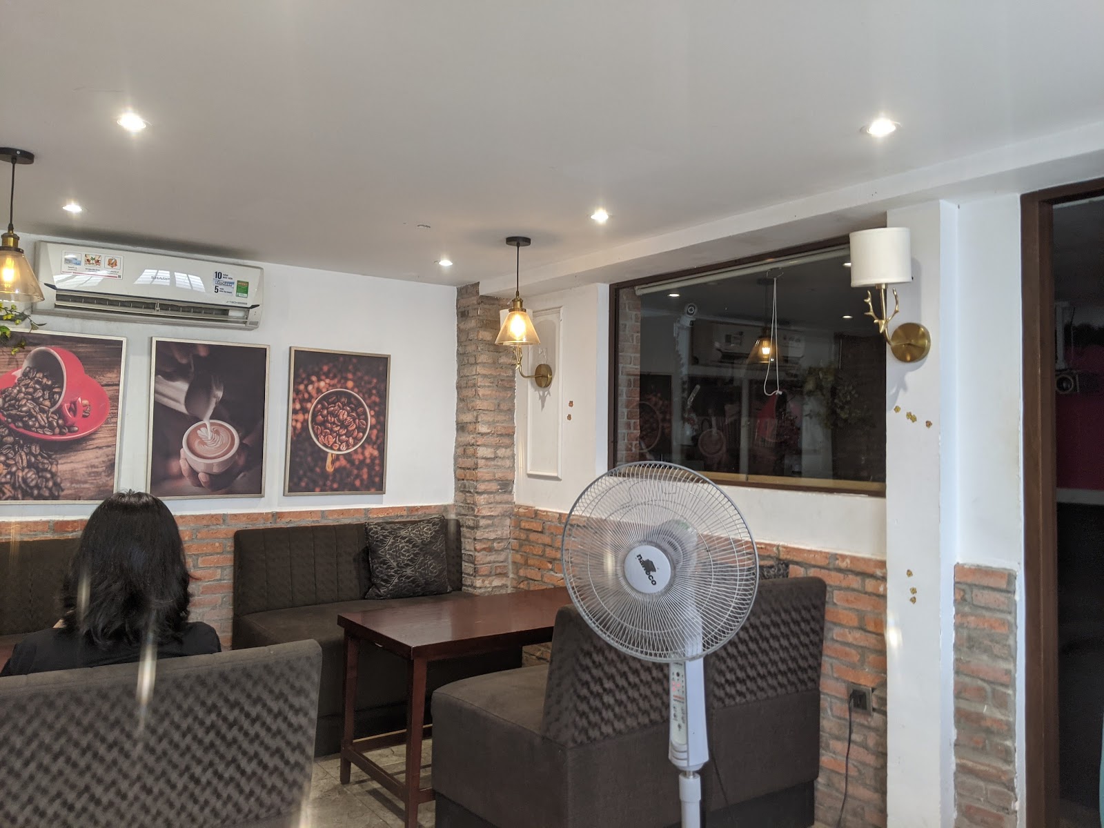 the shop interior with coffee-art posters, brick wainscoting and pendant lights