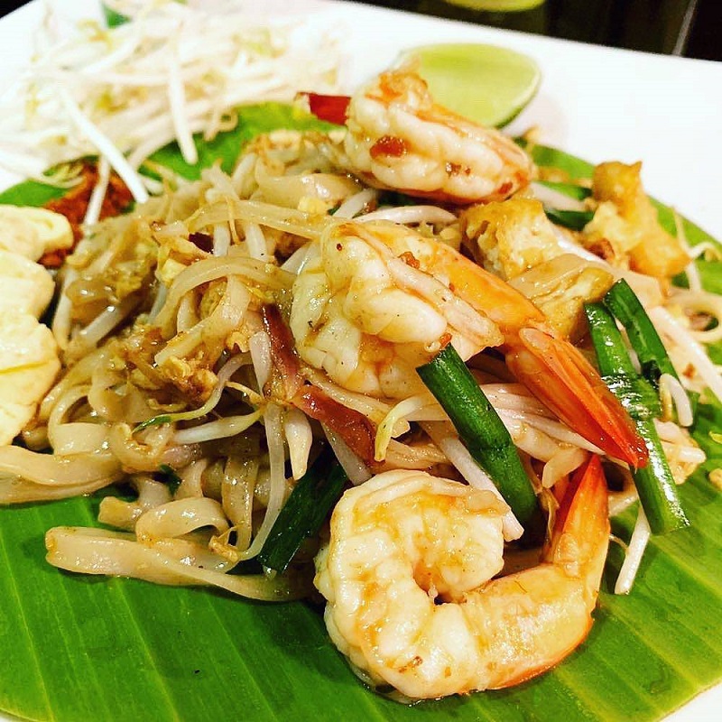 Pad Thai with shrimp on a banana leaf, with bean sprouts and lime