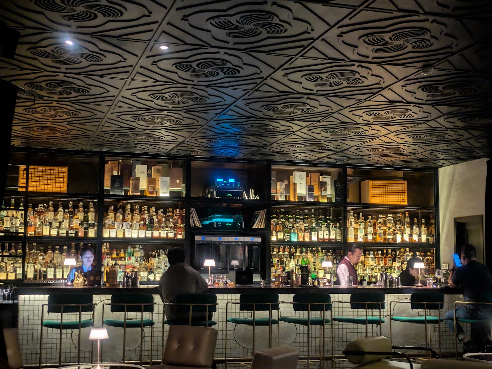 The CoCo whisky bar — backlit bottle shelves under the carved ceiling