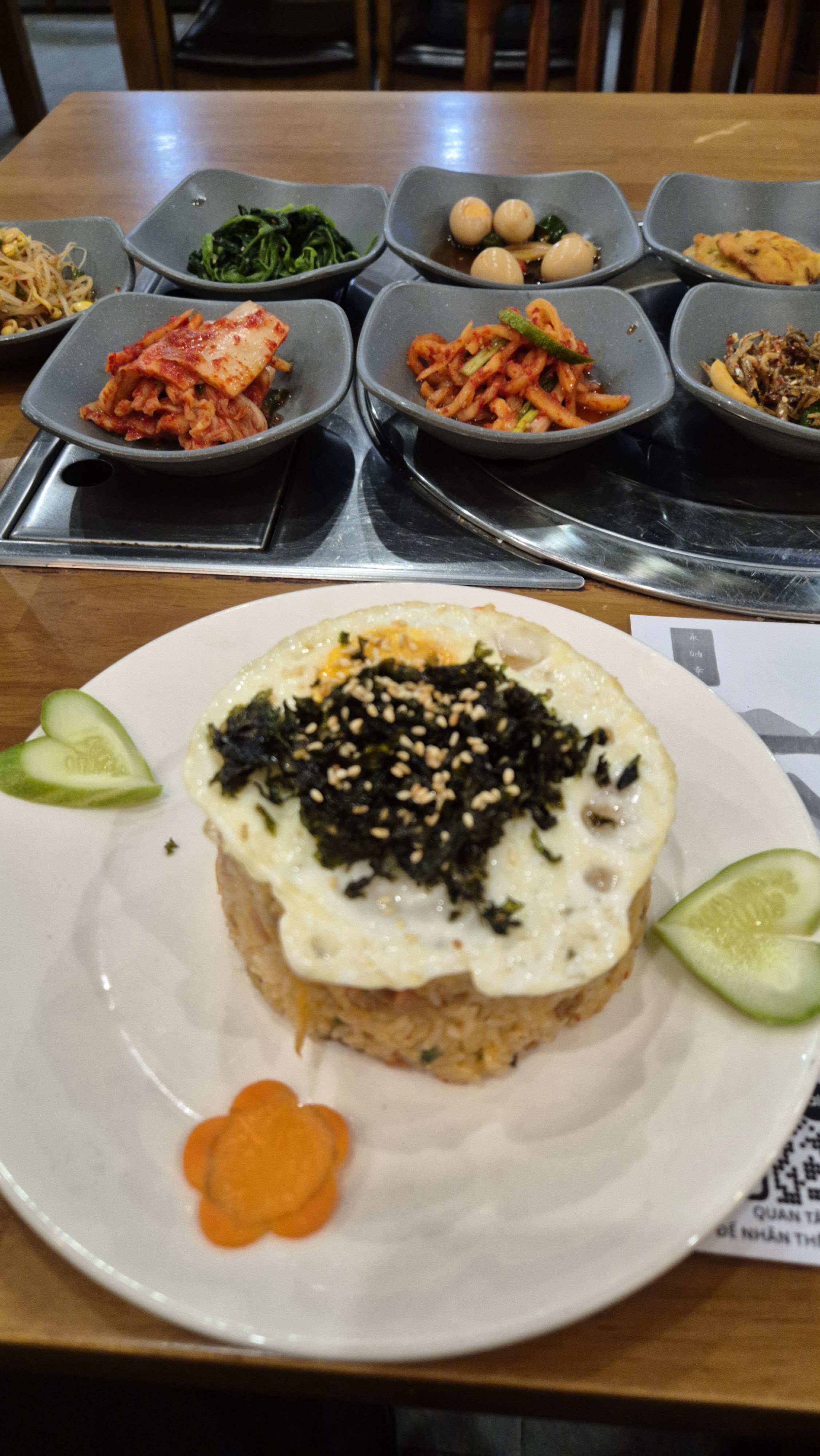 Hàng banchan chén xám và cơm chiên kimchi vòm trứng tại Doran Doran