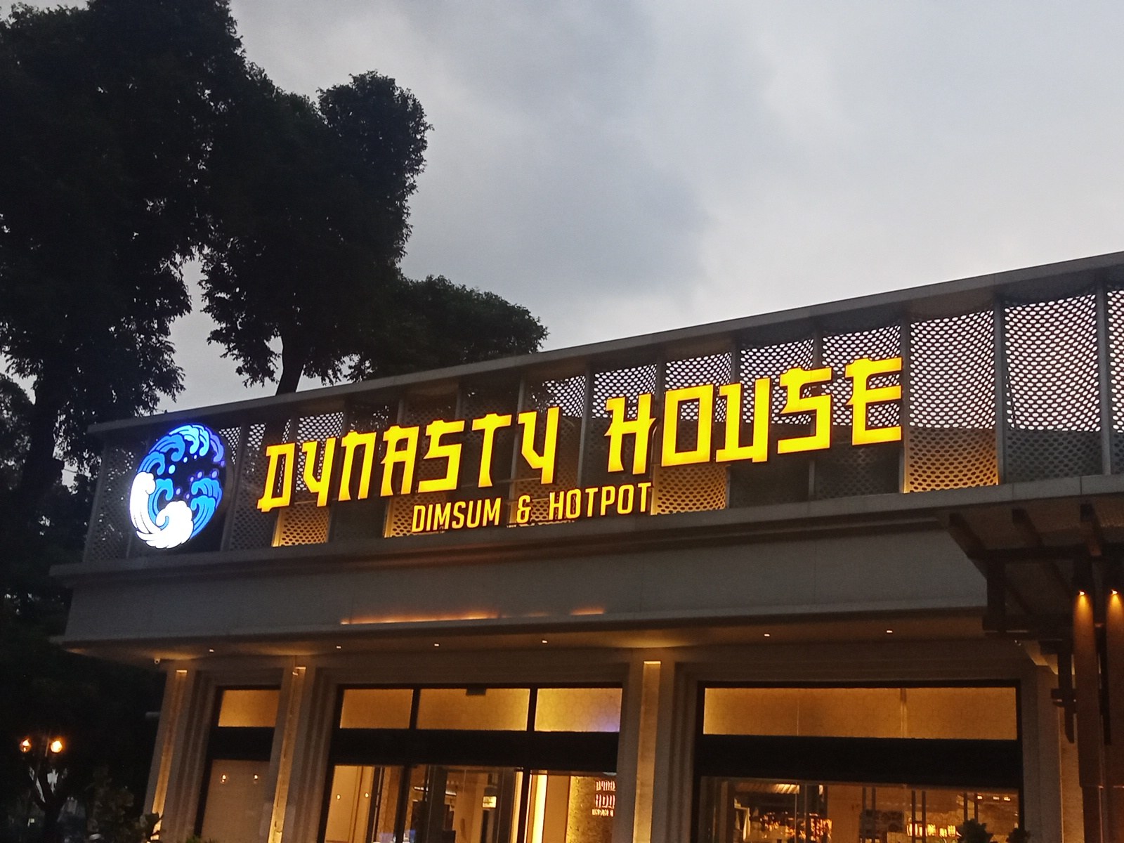 Bảng hiệu DYNASTY HOUSE vàng phát sáng về tối
