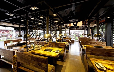 어두운 톤의 고기하우스 홀: 원목 부스, 검은 천장, 후드