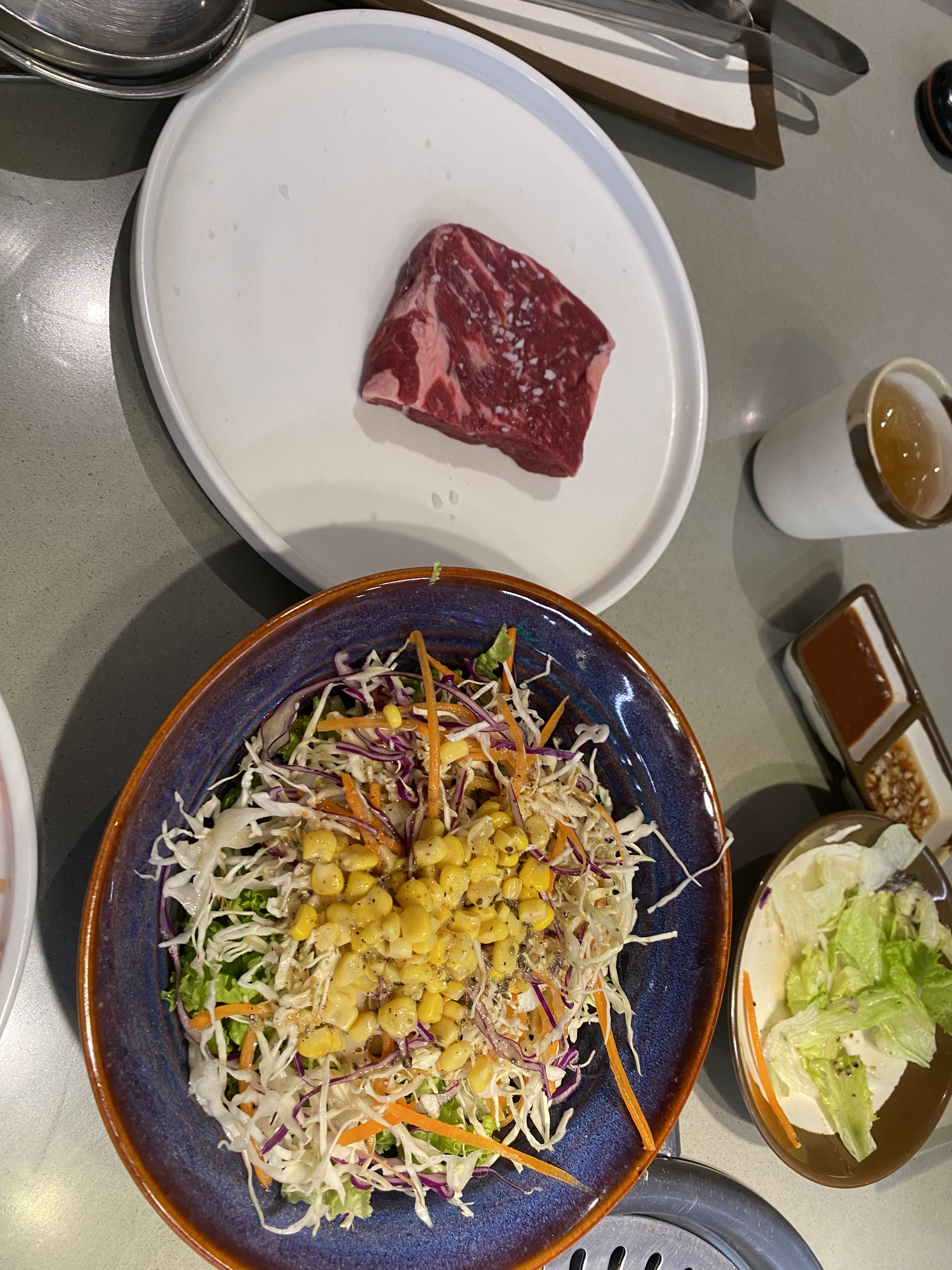 GoGi House Vincom Đồng Khởi — thịt bò Mỹ vân mỡ đang nướng trên vỉ (Kim Bich, 09/2026)