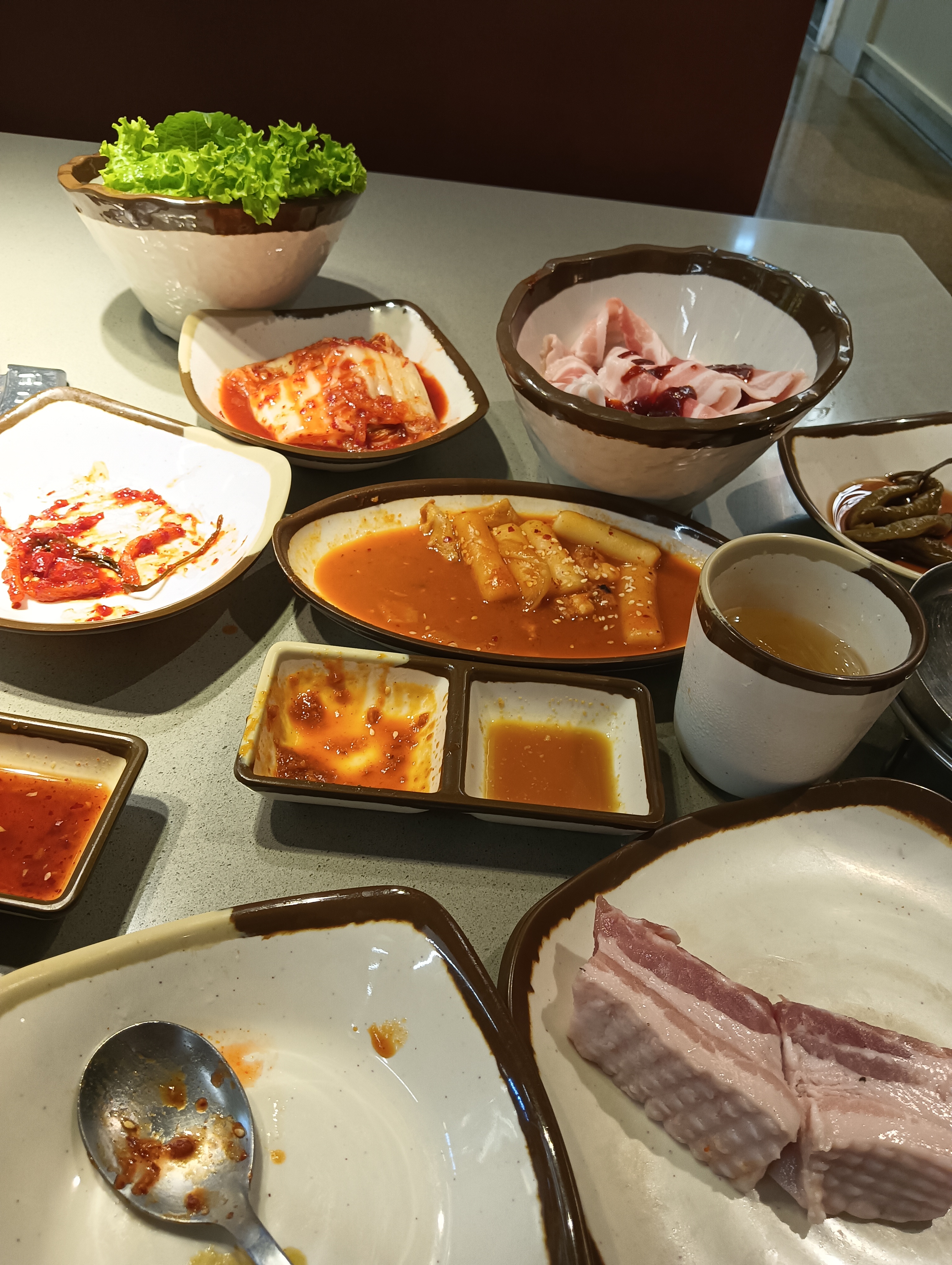 GoGi House Vincom Dong Khoi — raw pork belly and the banchan spread (Jasmine Hathaway, 08/2026)