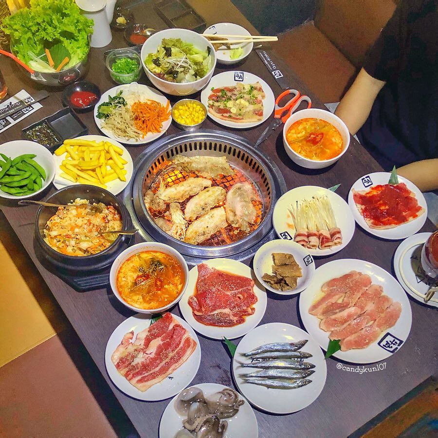 Cả bàn yakiniku: bếp than giữa vòng thịt bò, kim chi và rau