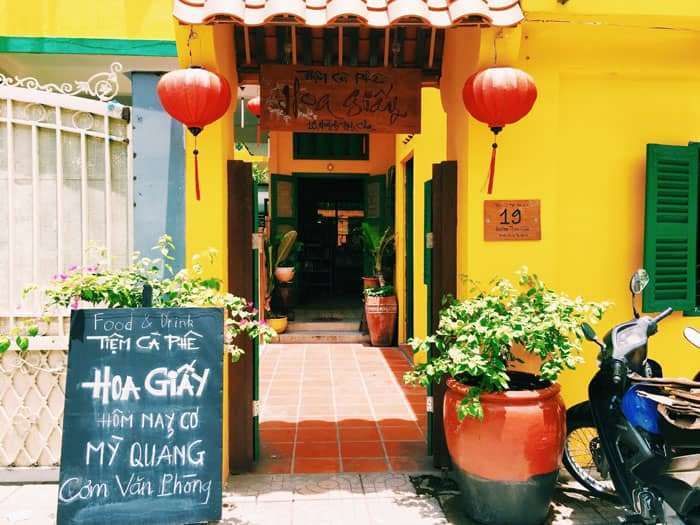 Cổng quán cận cảnh: lồng đèn, cửa chớp xanh, bảng “Hôm nay có Mì Quảng”