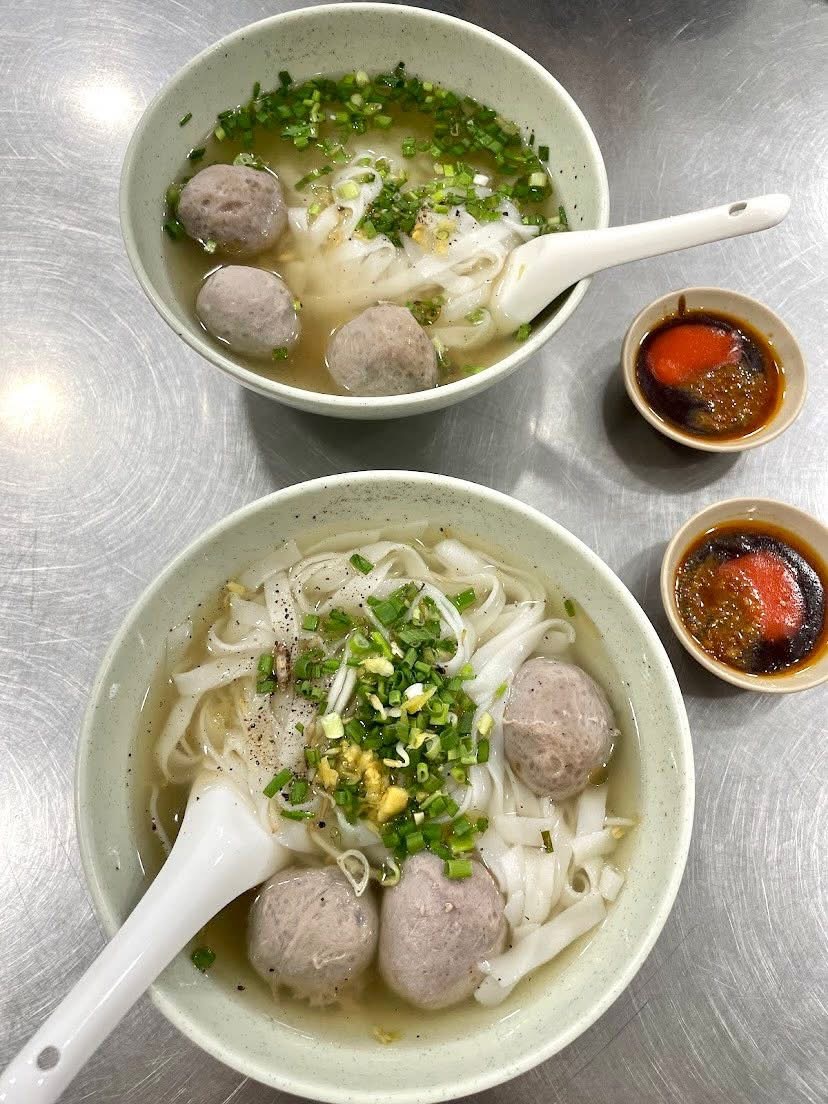Two bowls of beef-ball hu tieu on a stainless table — a guest's photo