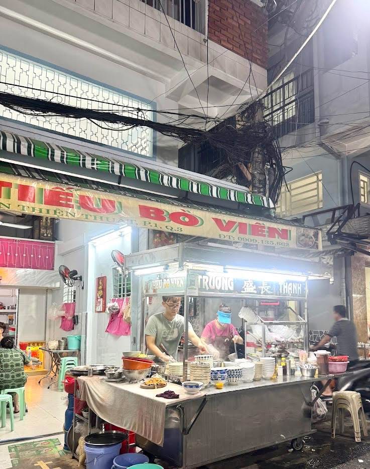 The shop's stainless cart at night — TRUONG THANH on the glass cabinet