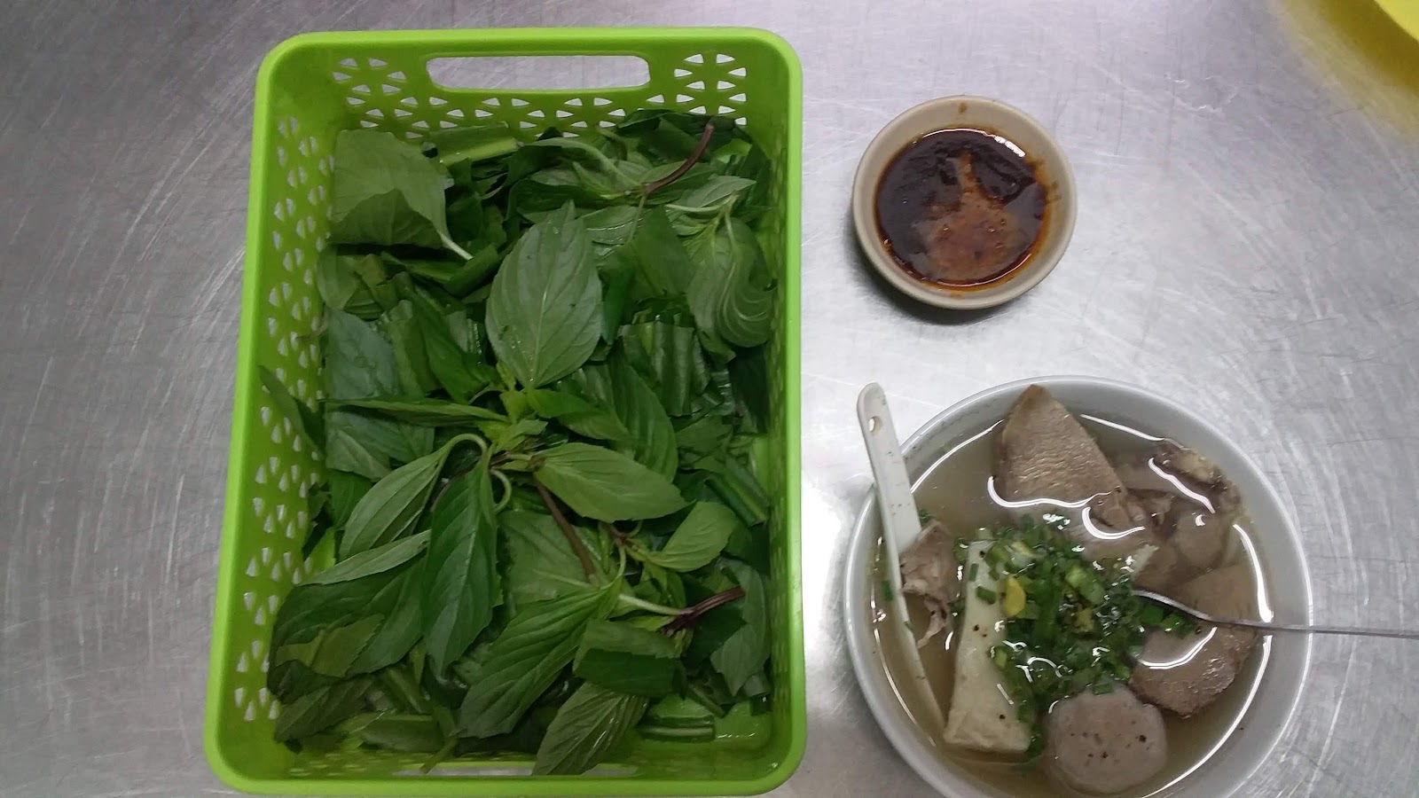 Basket of greens and a dipping-sauce bowl on stainless — a guest's photo