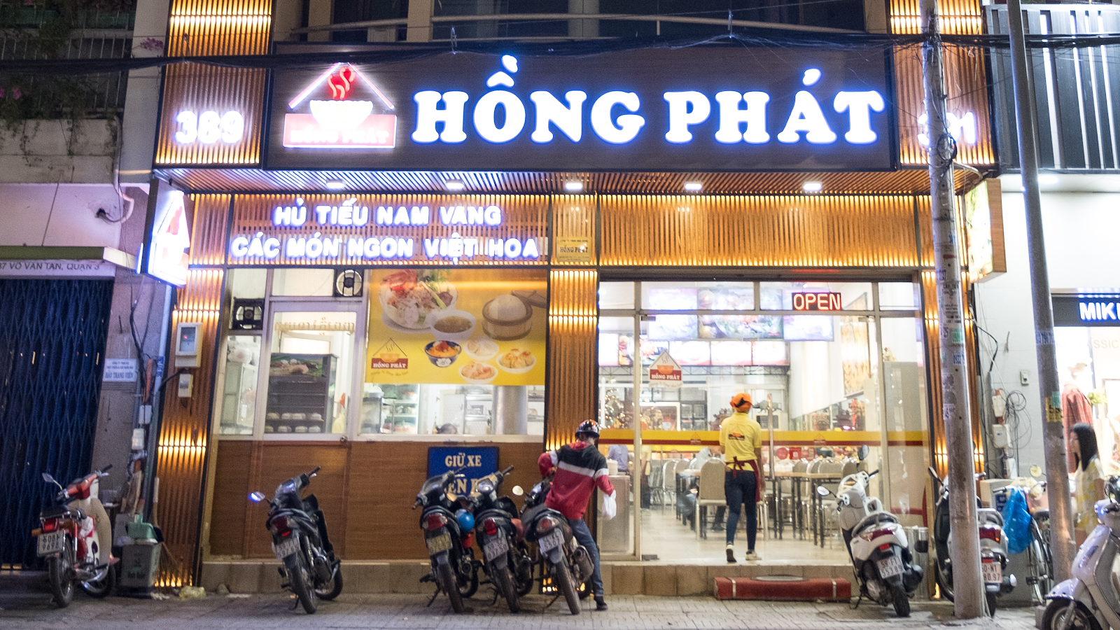 The Hong Phat storefront at night, 389 sign glowing