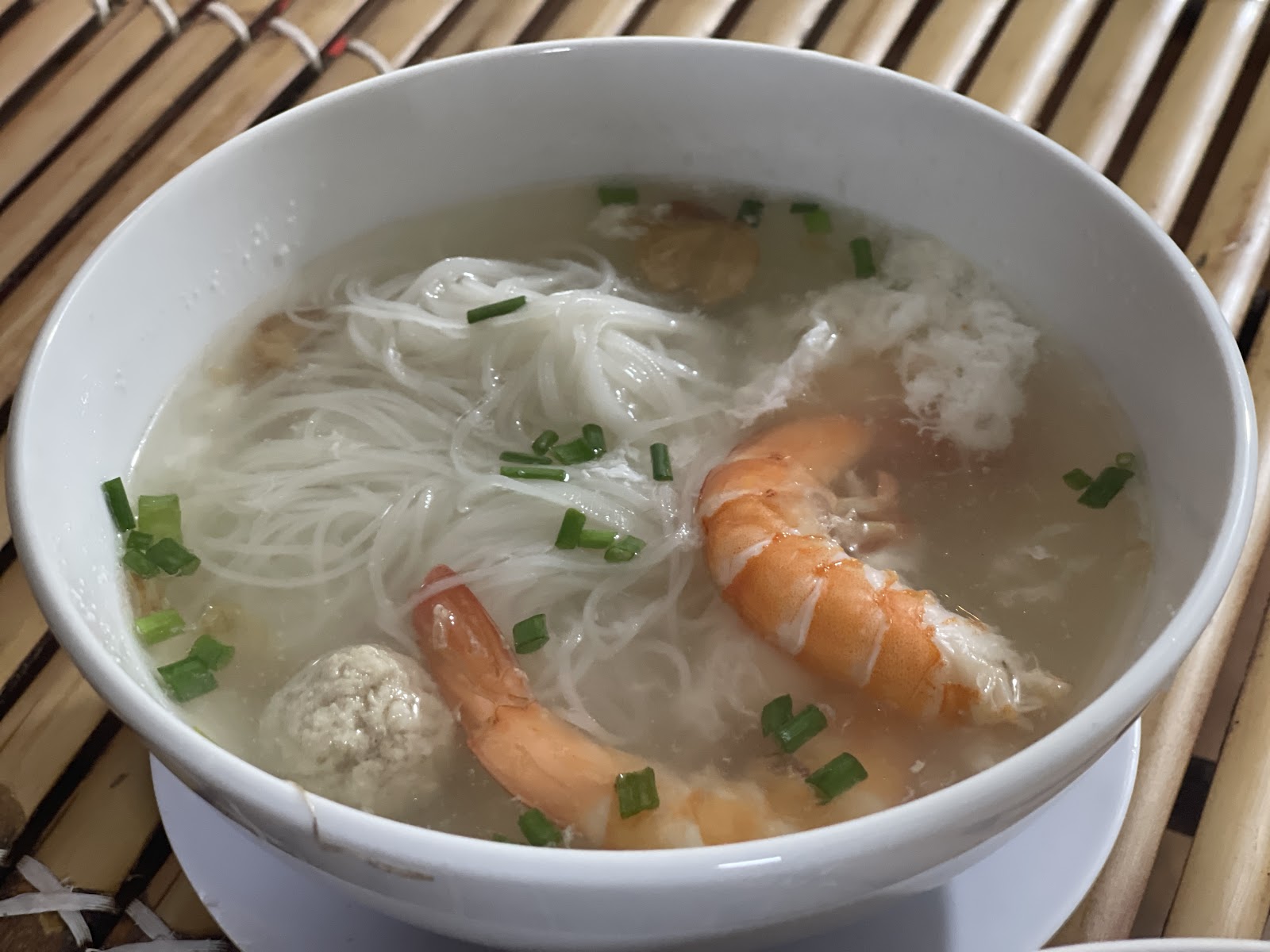 Tô hủ tiếu nước trong với tôm to và thịt viên, trên chiếu tre — ảnh của khách