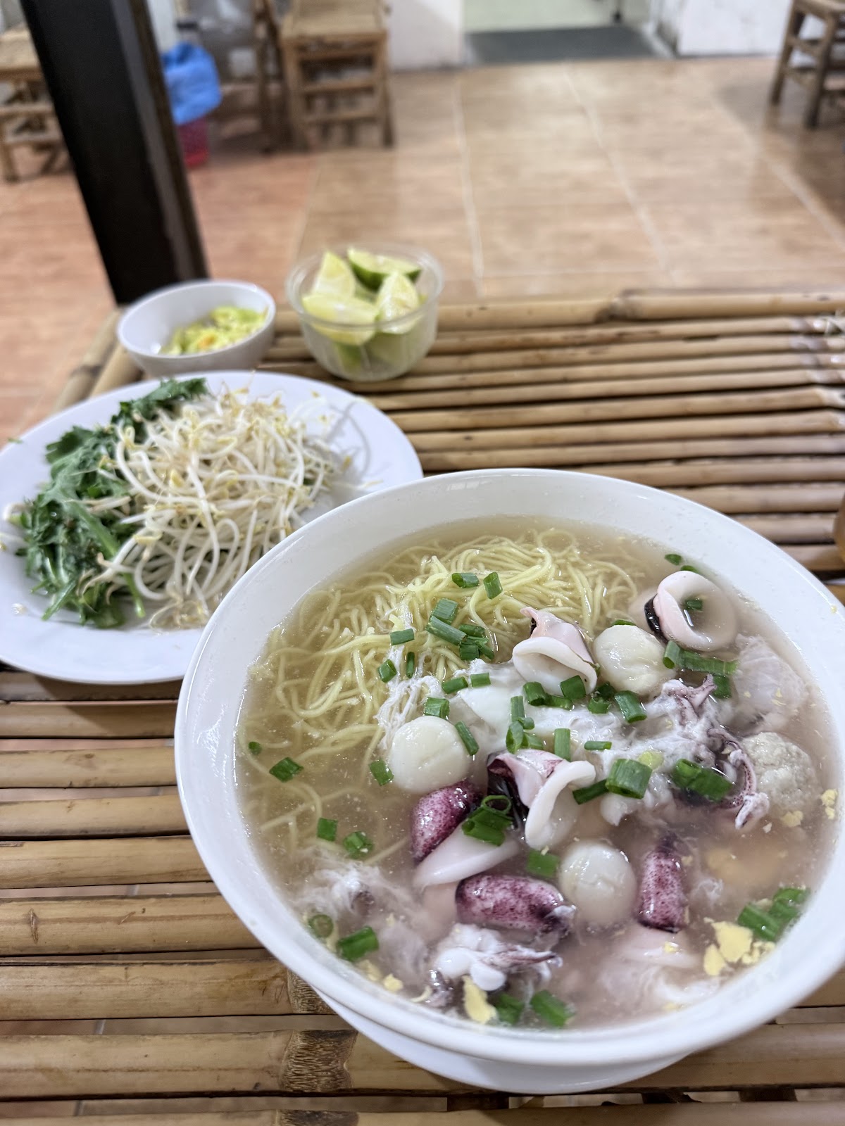 Tô hủ tiếu mực: mì, mực khoanh, chả cá, hành lá trong nước lèo trong — ảnh của khách