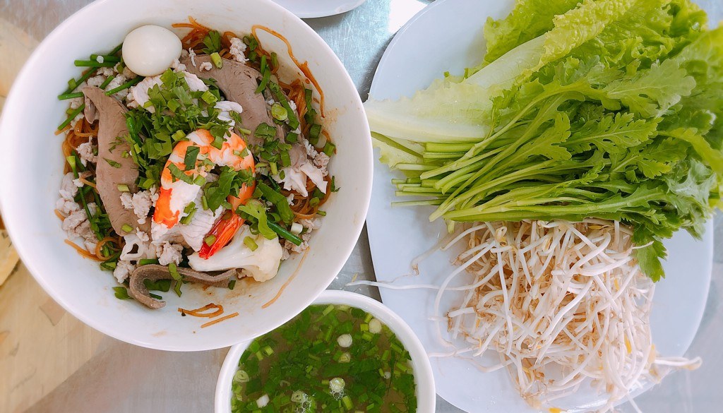 Dry hủ tiếu with fresh herbs