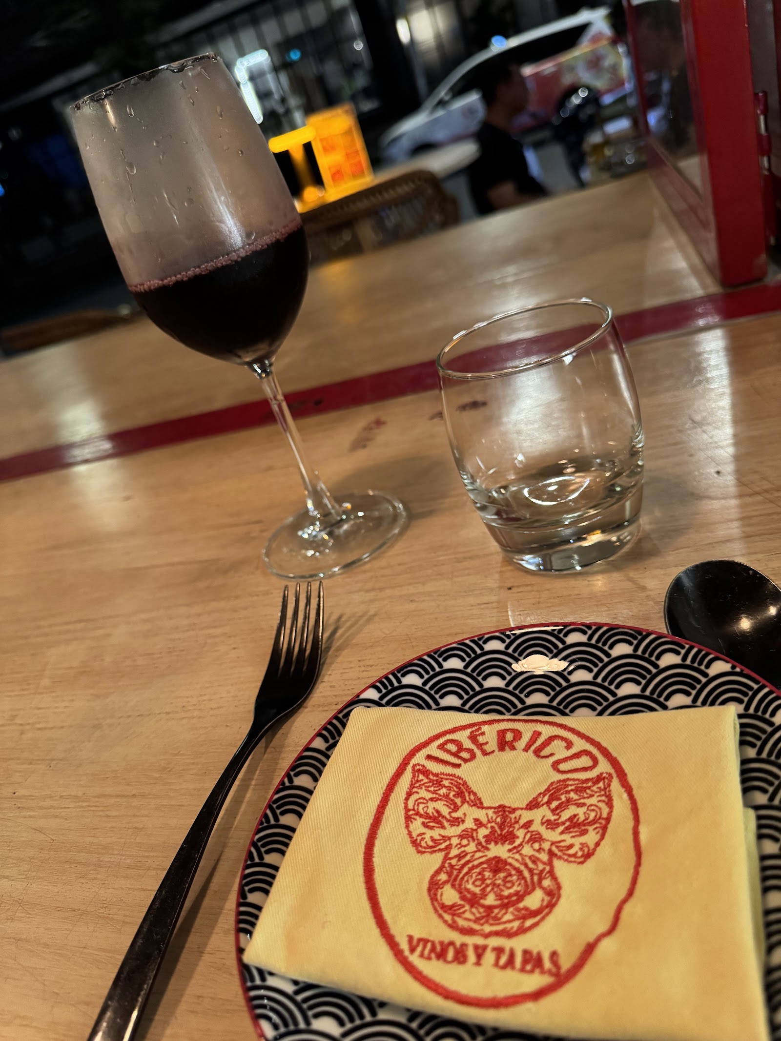 A glass of red wine beside the pig-stamped iBERICO napkin