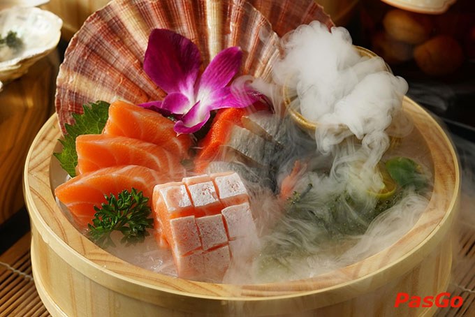 Sashimi cá hồi trên thuyền gỗ trong khói đá khô, hoa lan bên cạnh