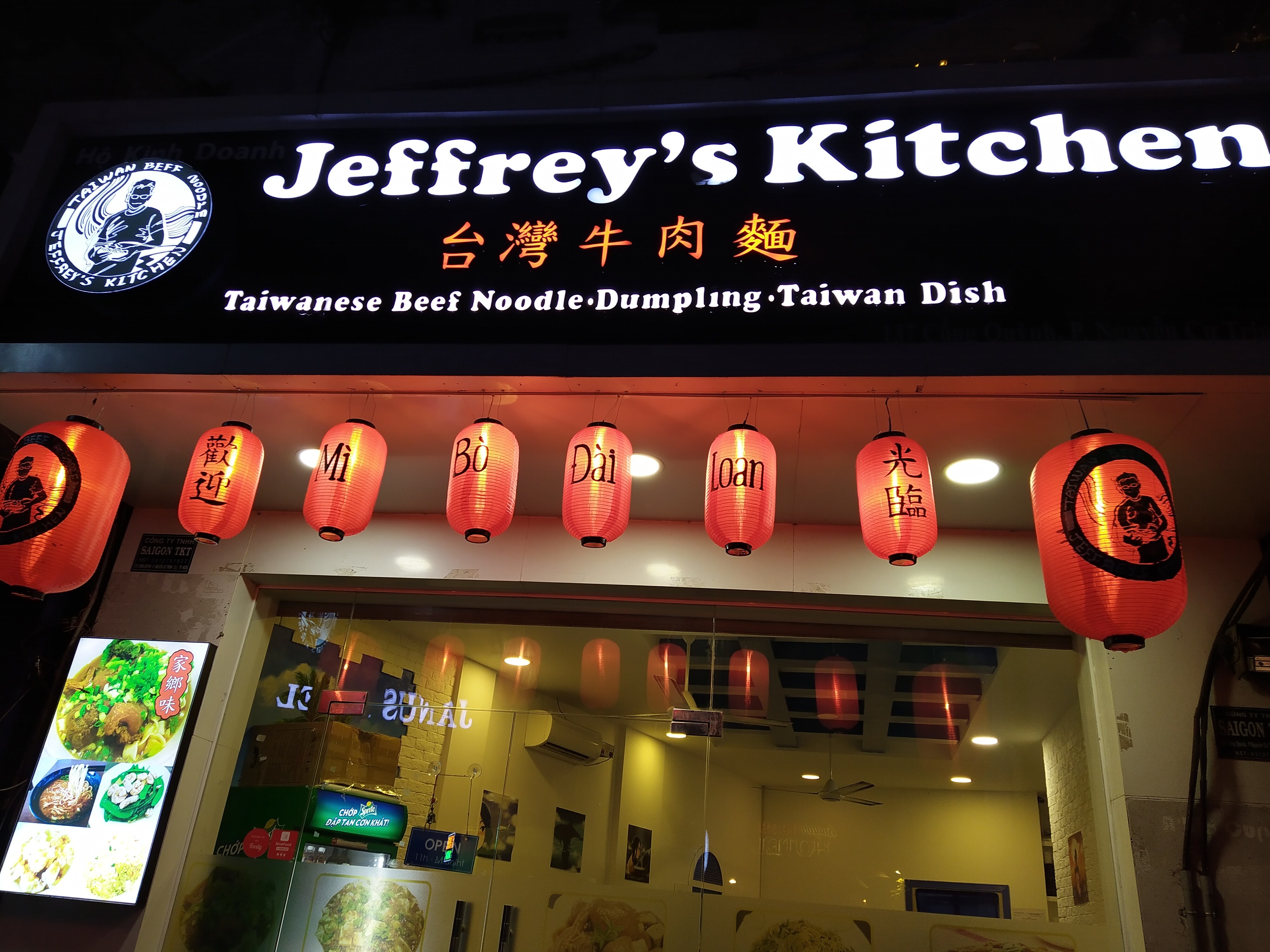 Jeffrey's Kitchen storefront glowing at night on Cong Quynh