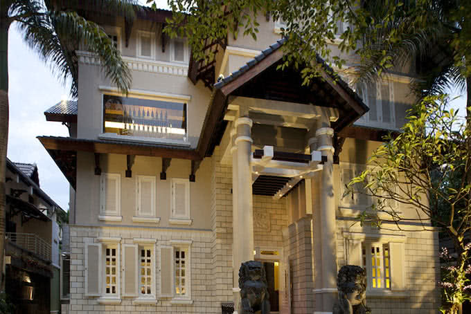 The French villa — white walls, tall columns, old trees