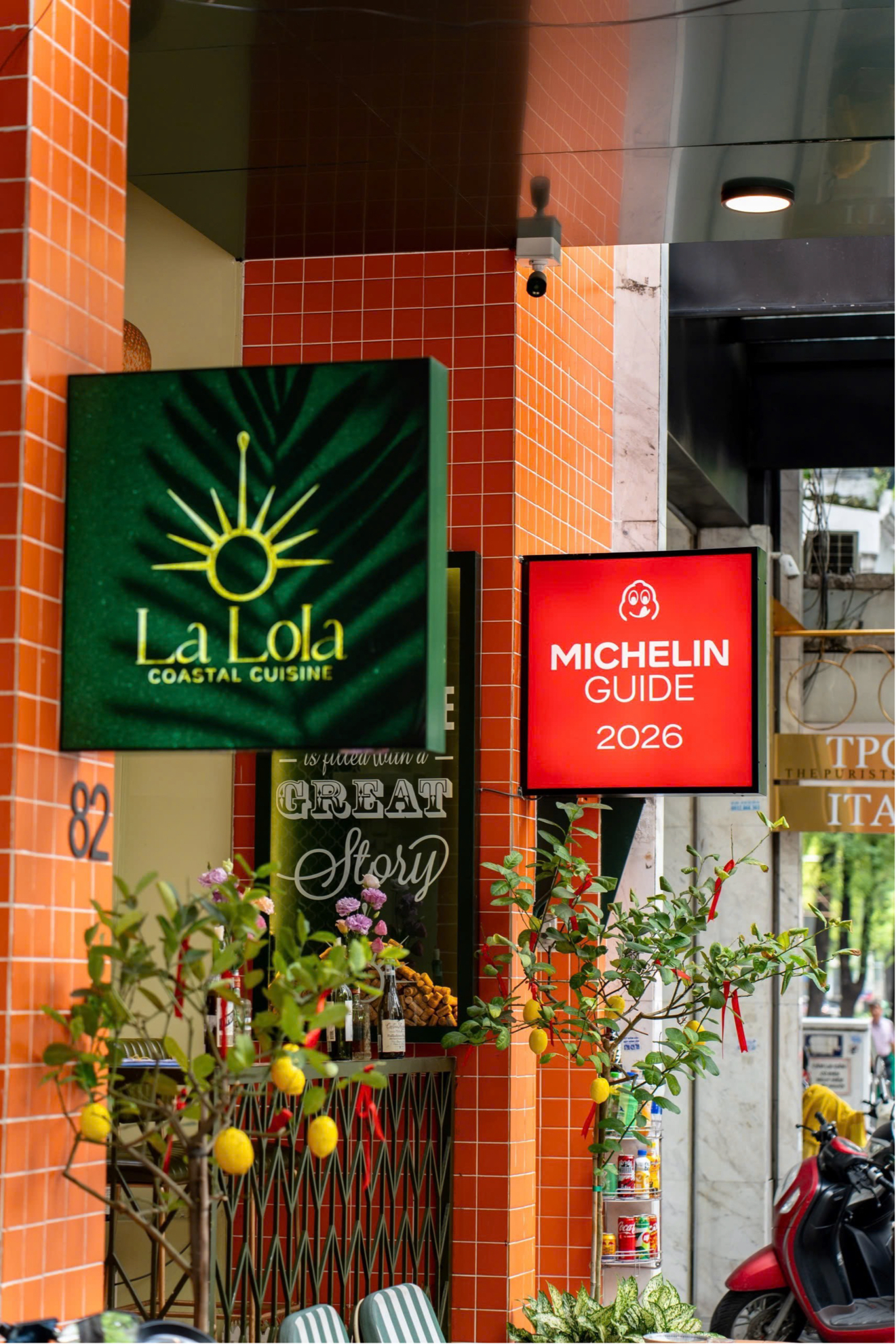 La Lola's facade by day with the green sign and the Michelin Guide 2026 plaque