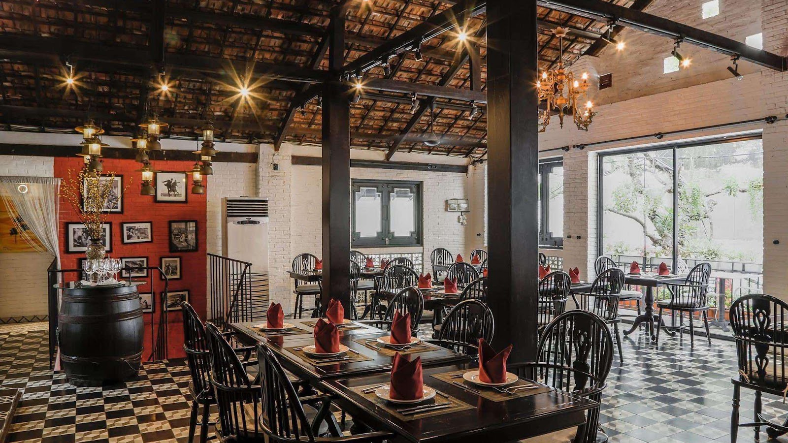 Phòng ăn với thùng rượu gỗ sồi trên sàn caro đen trắng — bàn ghế gỗ, ánh đèn ấm