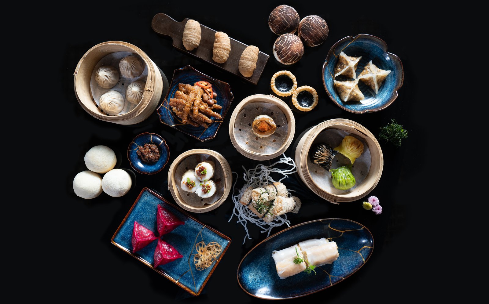The dim sum spread — bamboo steamers, cheung fun, dumplings on blue plates