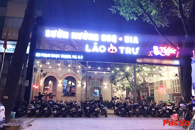 The Lao Tru facade at night: the big lit sign, the flaming letter O