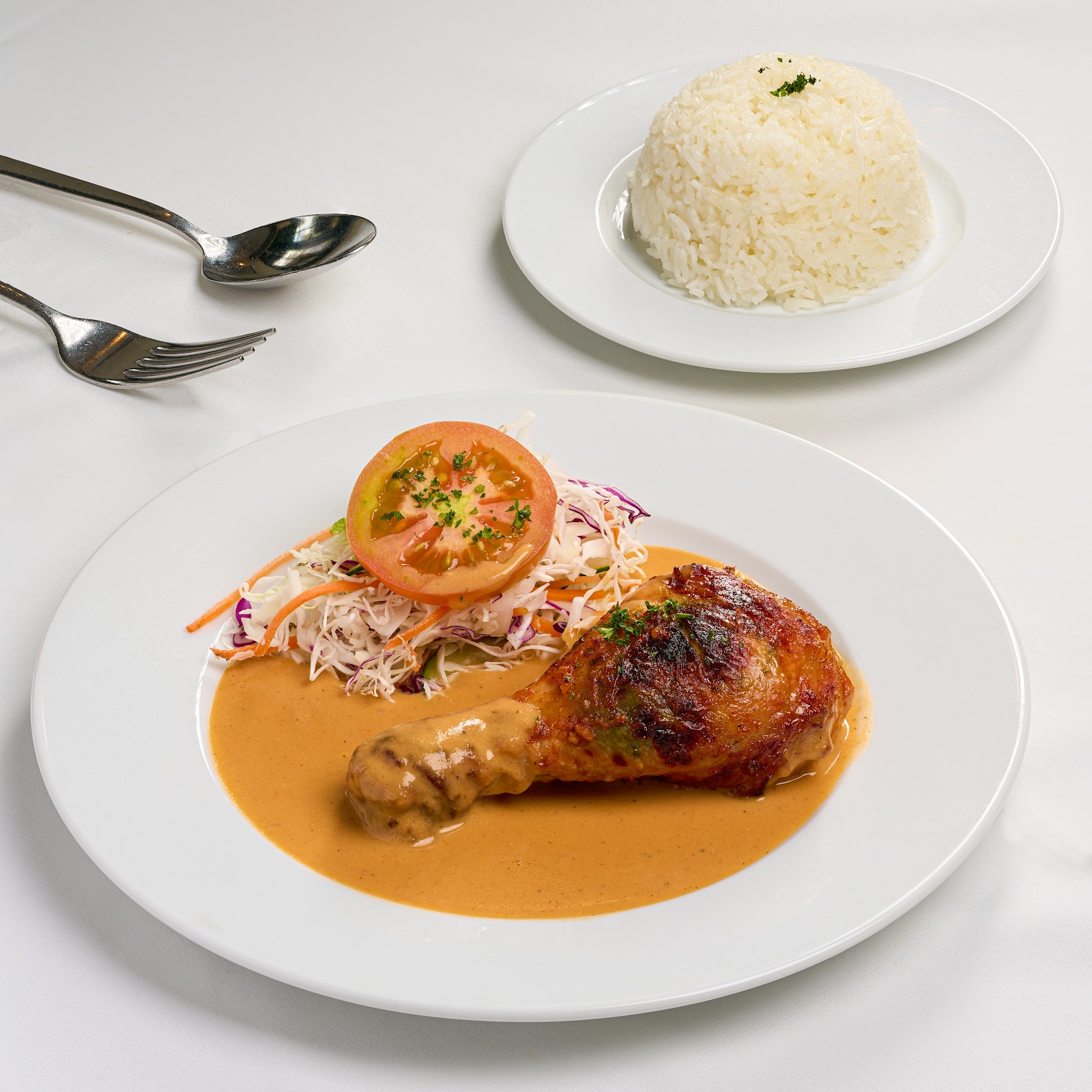 The French roast chicken leg in brown sauce with salad, tomato and a dome of rice — L'Etoile's signature