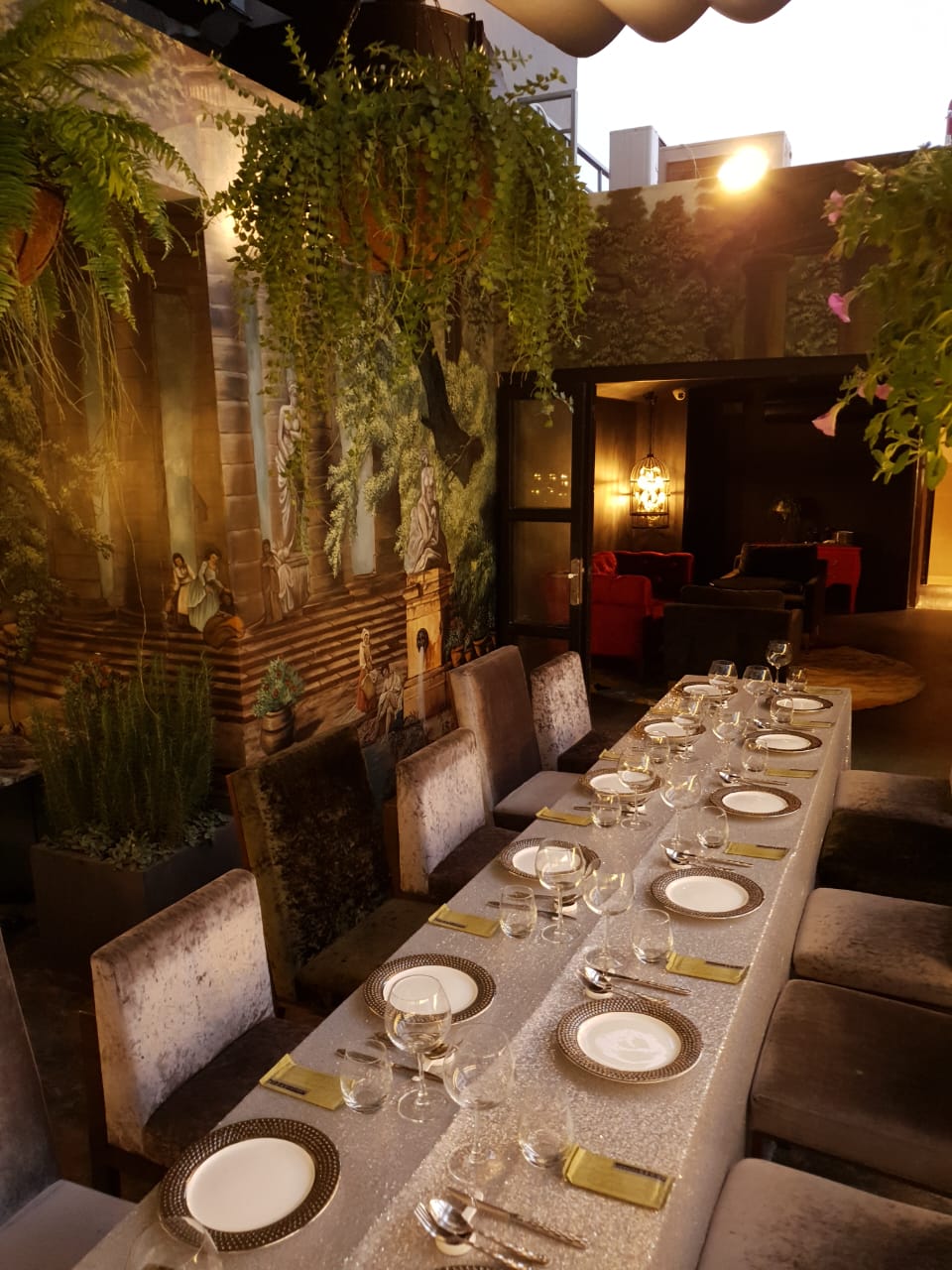 The long dining room with hanging ferns and a Singapore mural