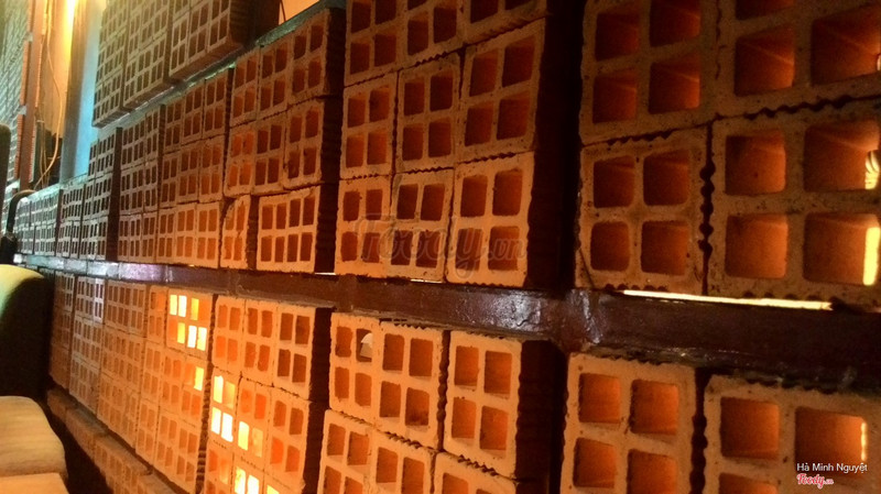 The glowing breeze-block wall: amber light filtering through every brick hole