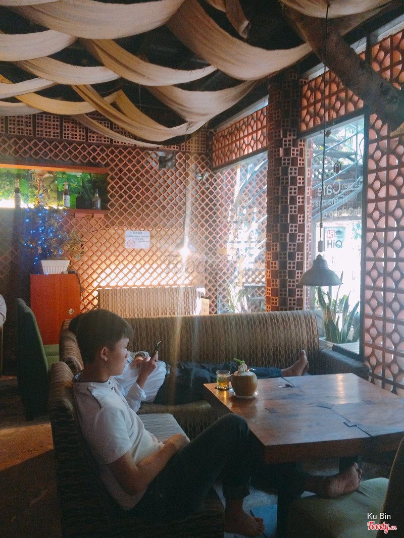 The ground-floor lounge: brick walls, draped fabric, guests relaxing