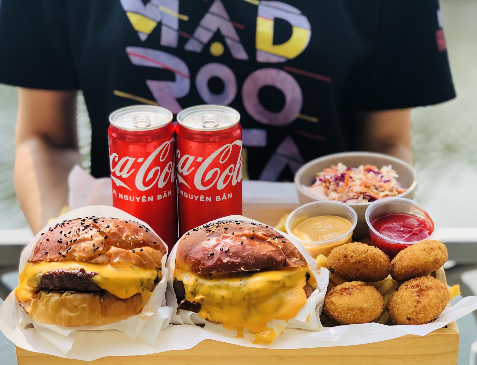 Khay burger trên bàn gỗ khắc tên MAD ROOSTA