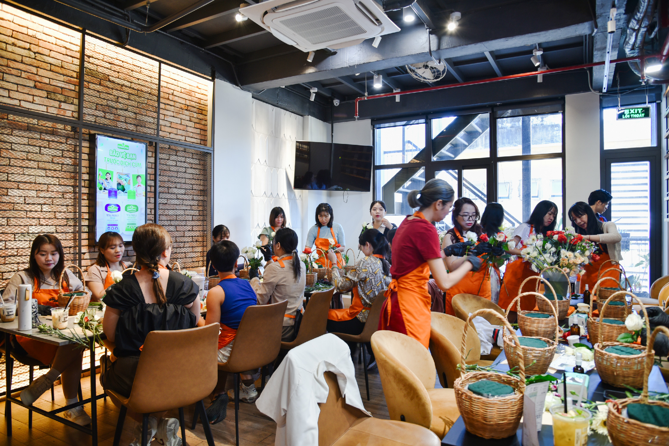 Workshop cắm hoa với khách mặc tạp dề cam