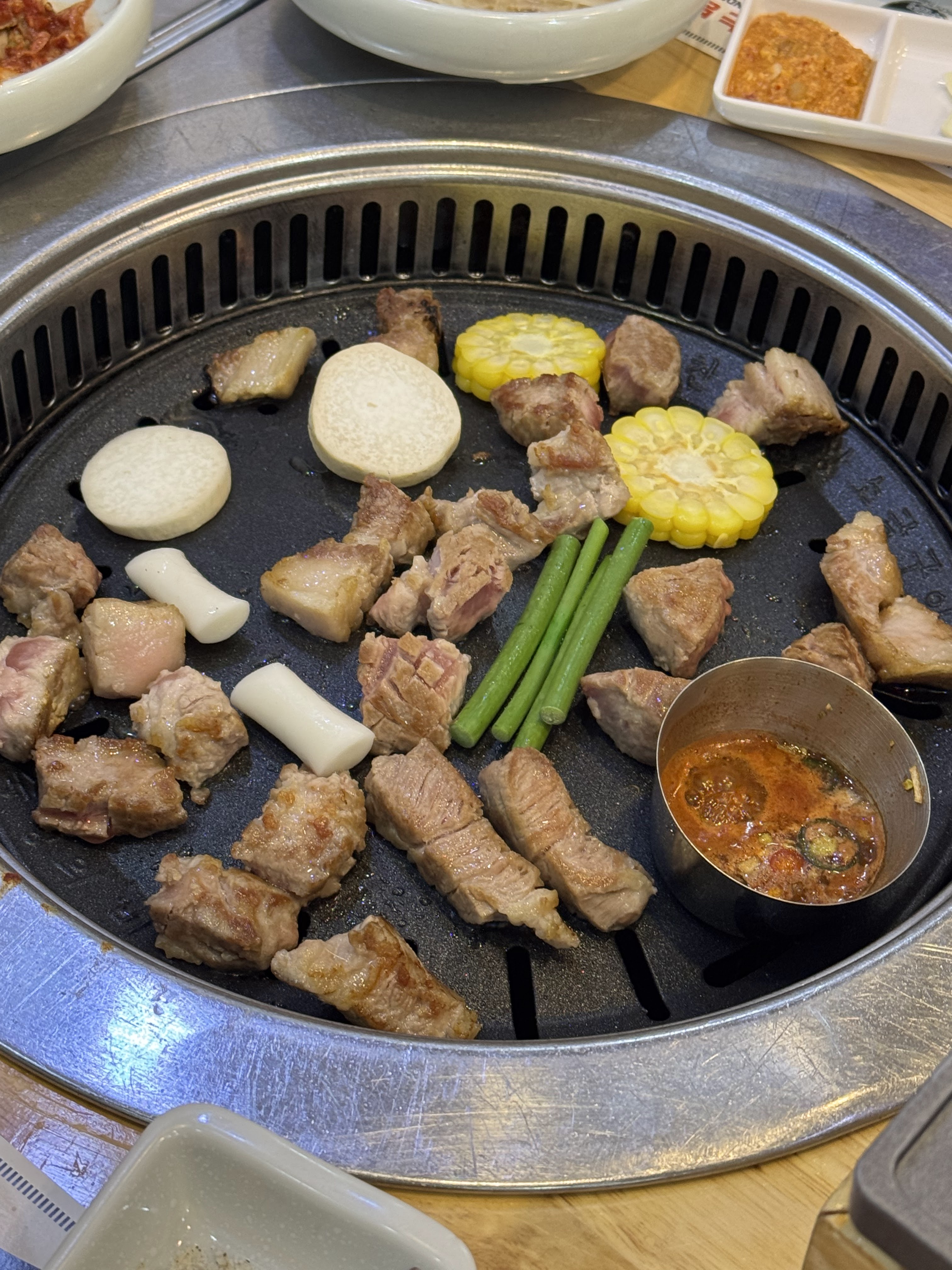 맛찬들 그릴에서 구워지는 두툼한 돼지고기 큐브