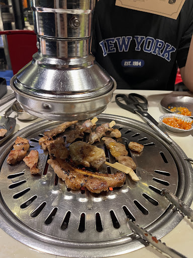 Meat grilling over charcoal embers at MEAT & MEET Lê Thị Riêng