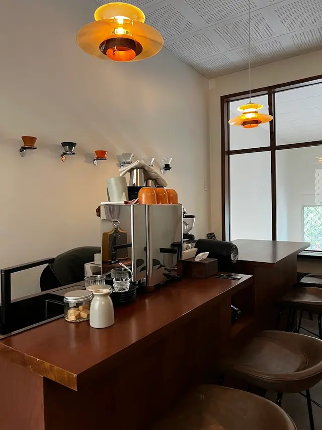Mew Roastery SG — quầy đảo, mặt gỗ óc chó trên chân xanh xám