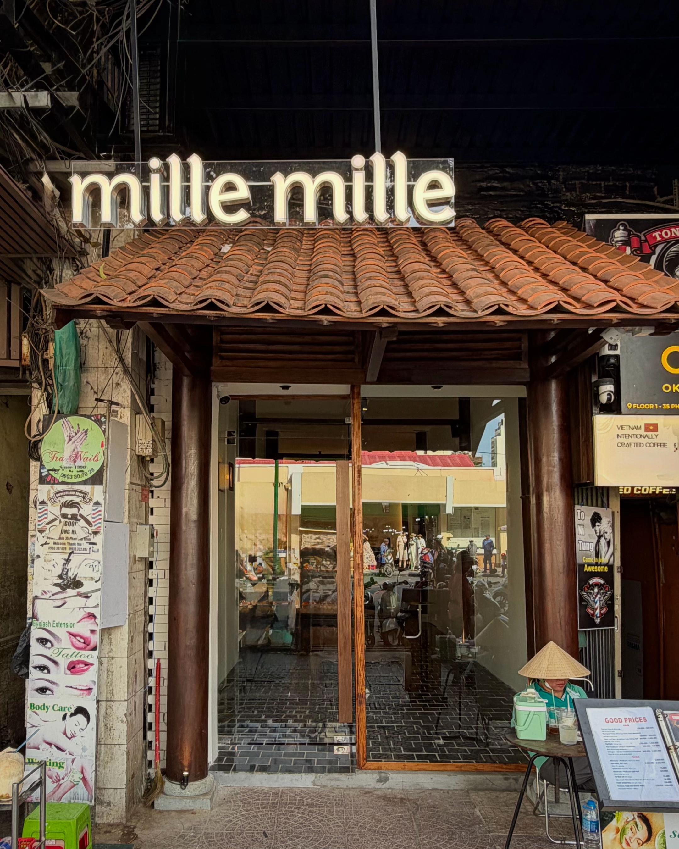 Mille Mille Ben Thanh — the entrance: dark wooden pillars, A-frame menu stand