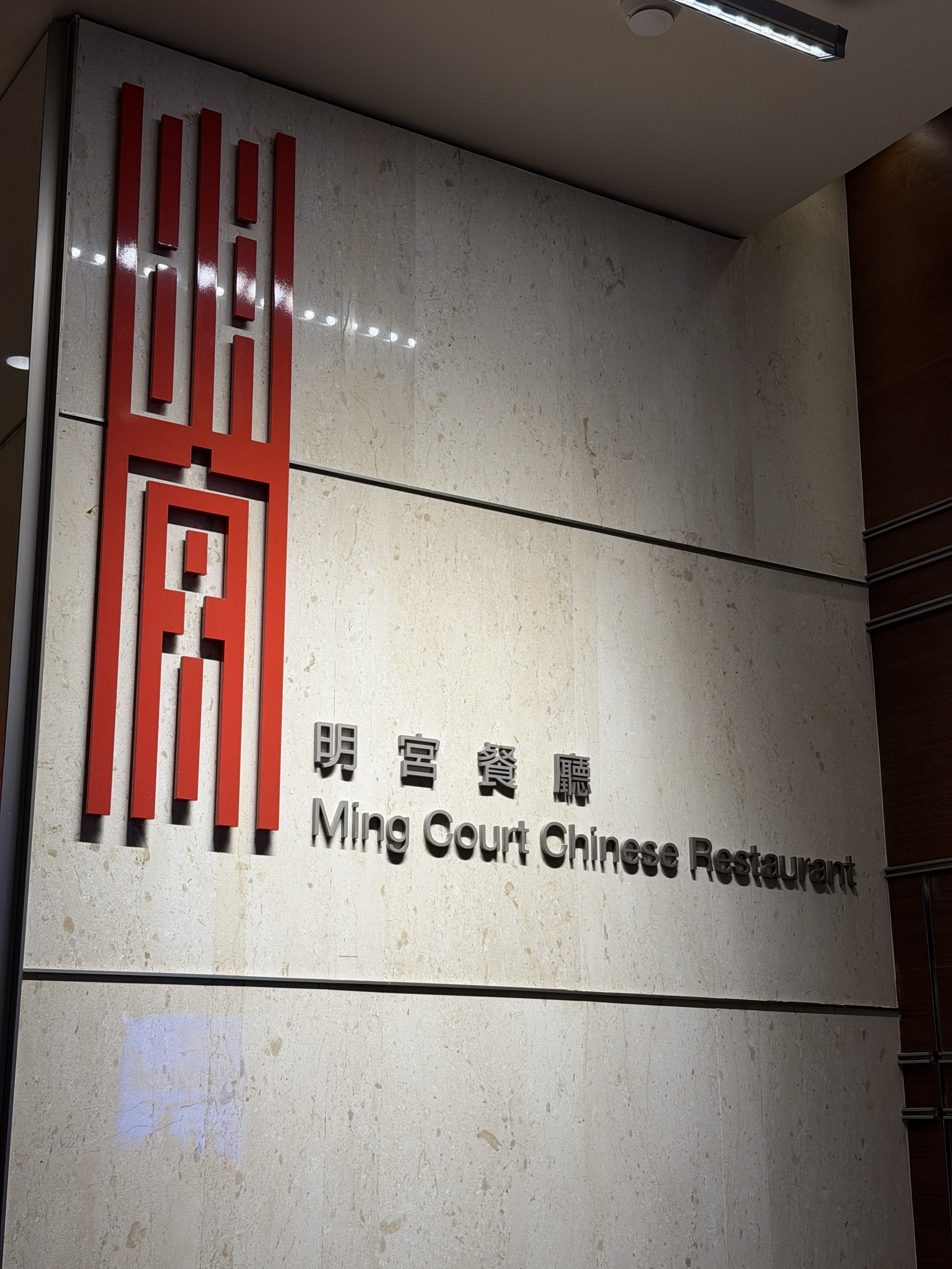 Bảng hiệu Ming Court — họa tiết đỏ hình học, chữ 明宫餐厅 trên tường đá