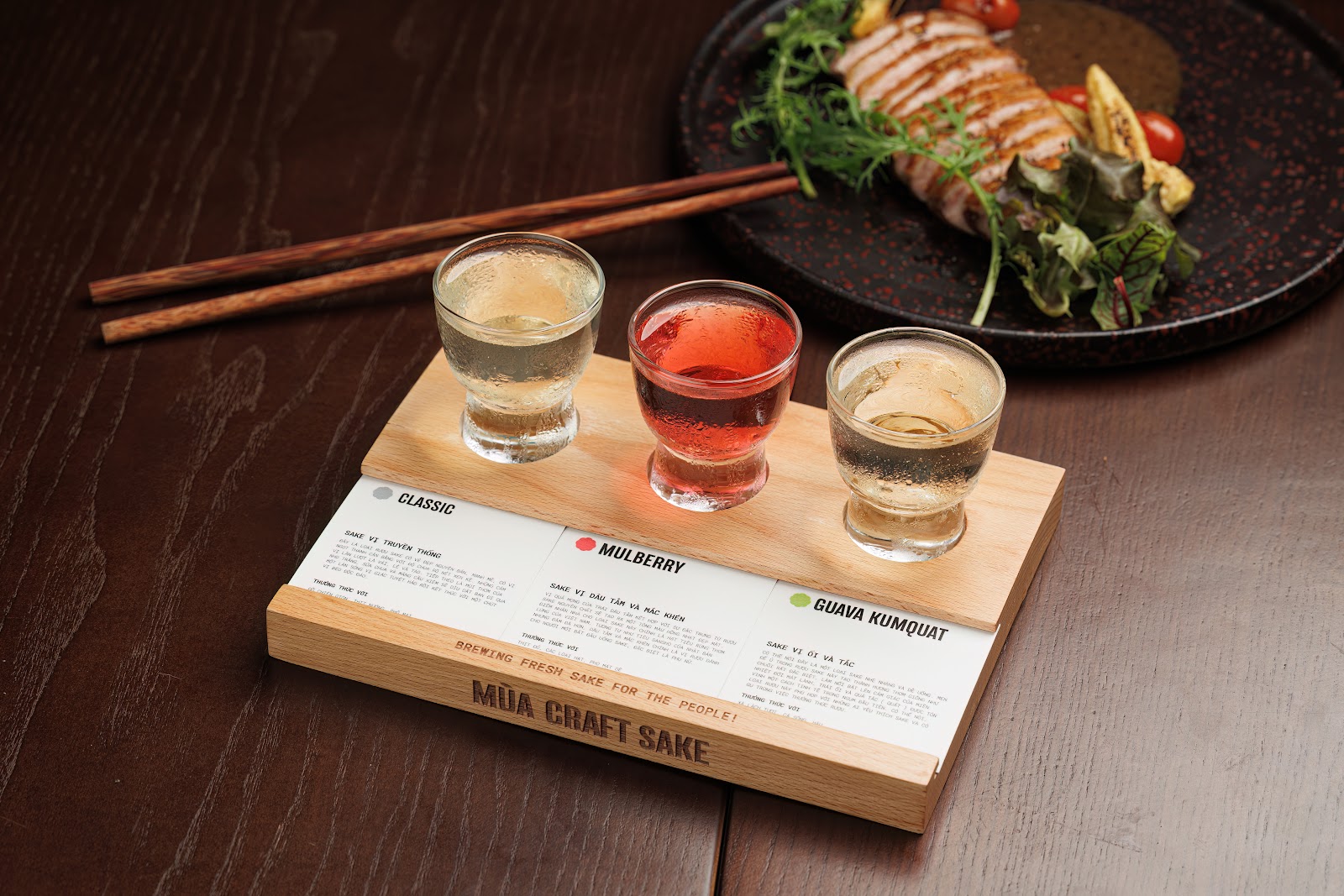Sake flight on the branded wooden paddle, with tasting cards