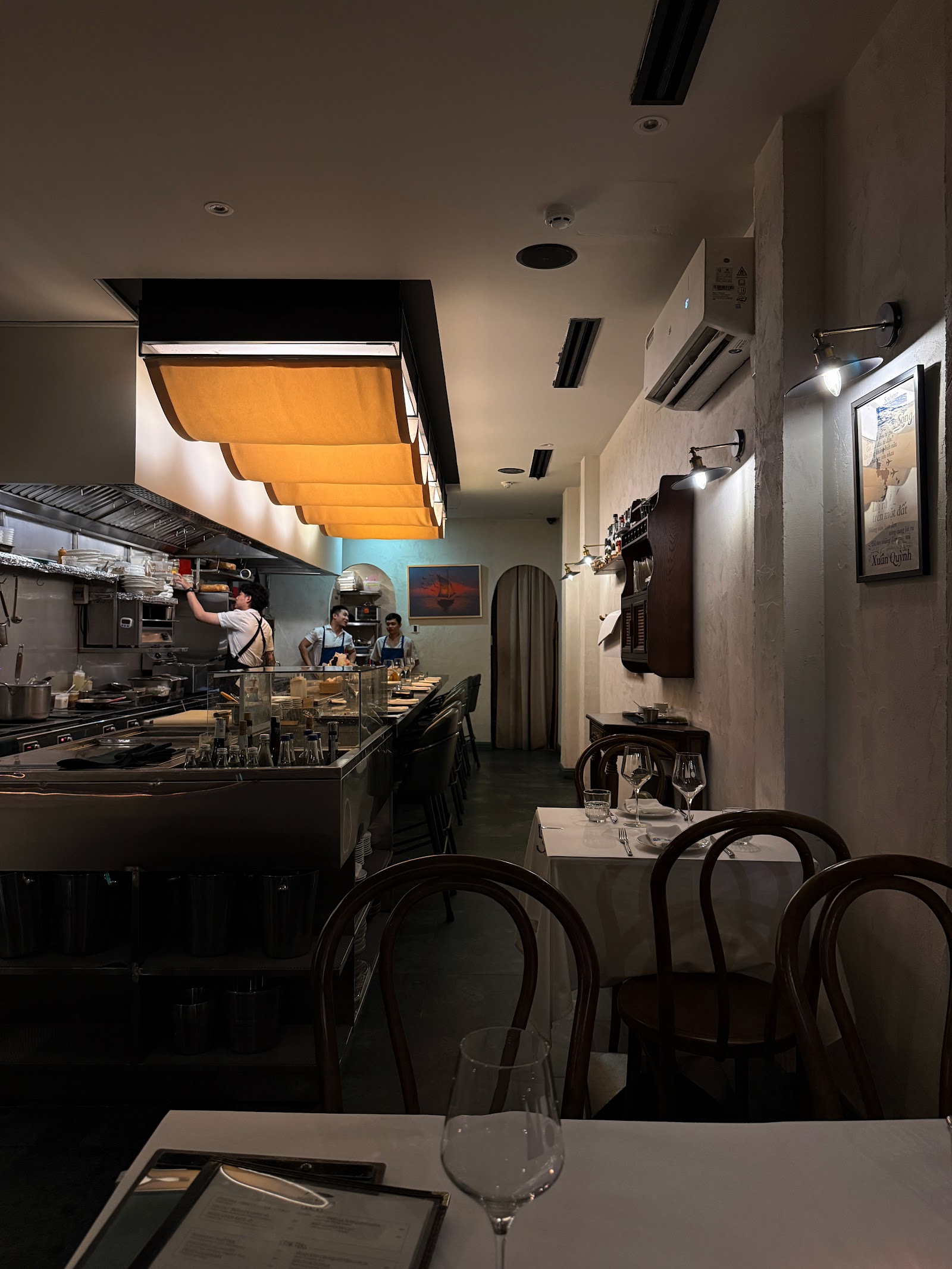 The Muội dining room — dark, intimate, with brass details