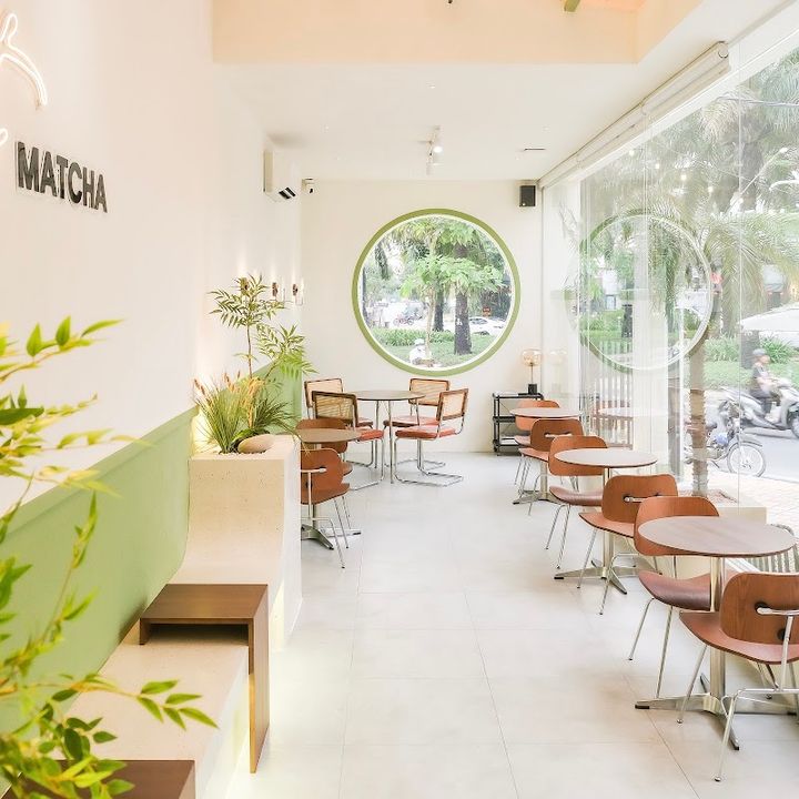 Góc bên trong Nhà Ba Teria: tường xanh matcha, cửa sổ tròn khung xanh, biển MATCHA, ghế đất nung