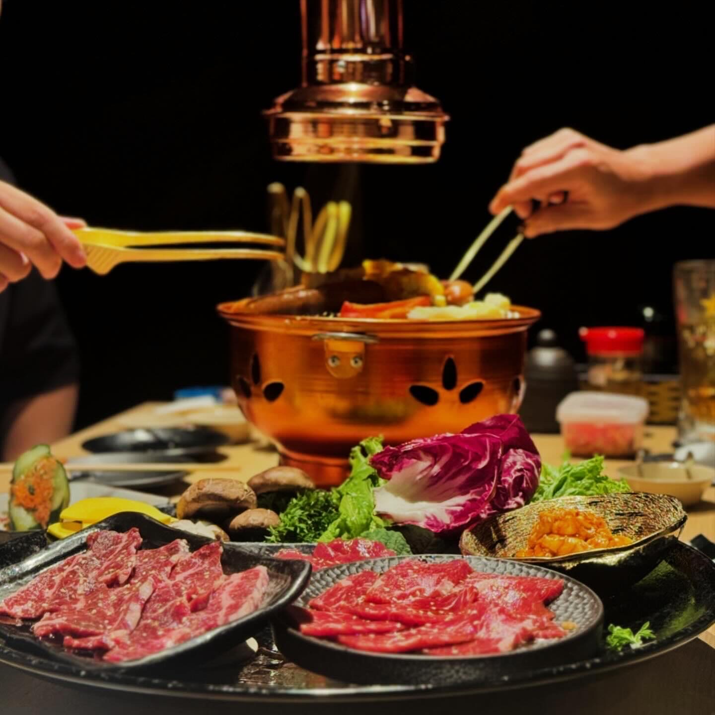 Meat grilling over charcoal at NIKUTARO